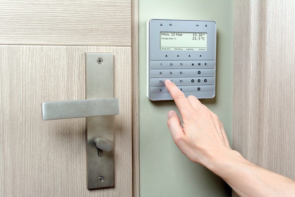 A Person Is Pressing a Button on A Security System — Fortress Locksmiths & Security in Lennox Head, NSW