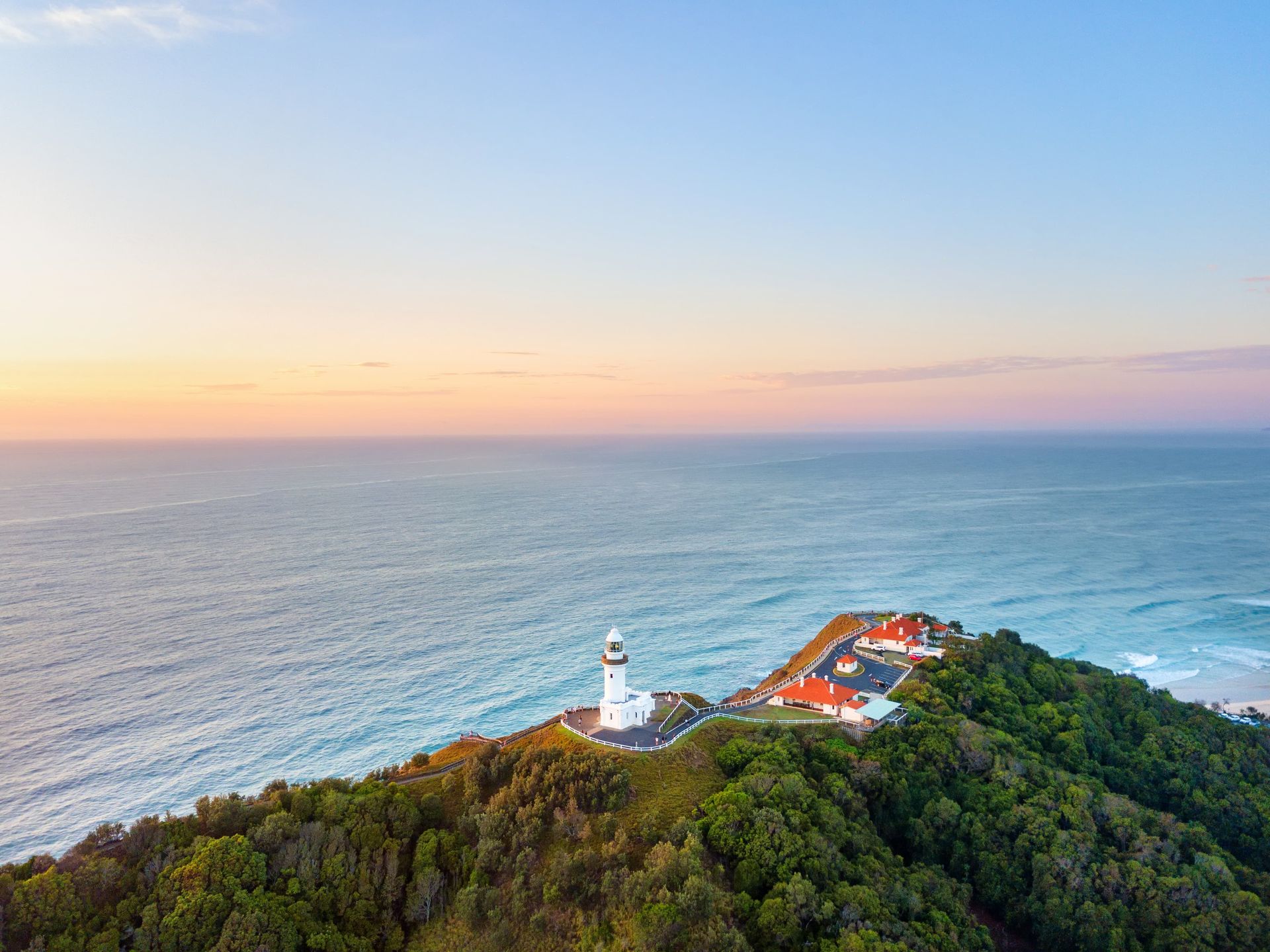 A Person Is Standing on A Cliff Overlooking a Beach — Fortress Locksmiths & Security in Byron Bay, NSW
