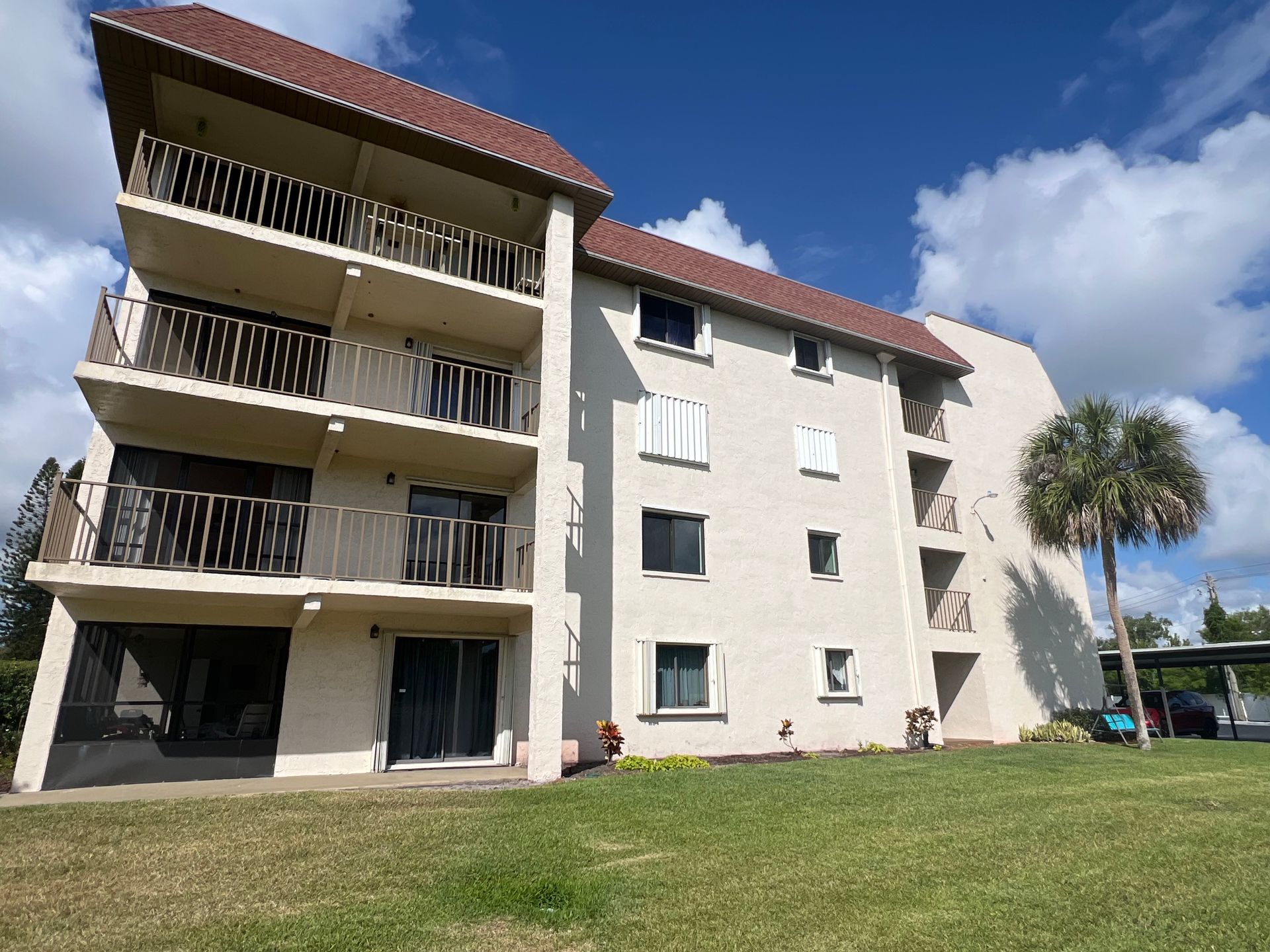 white condominium with red roof and green grass around