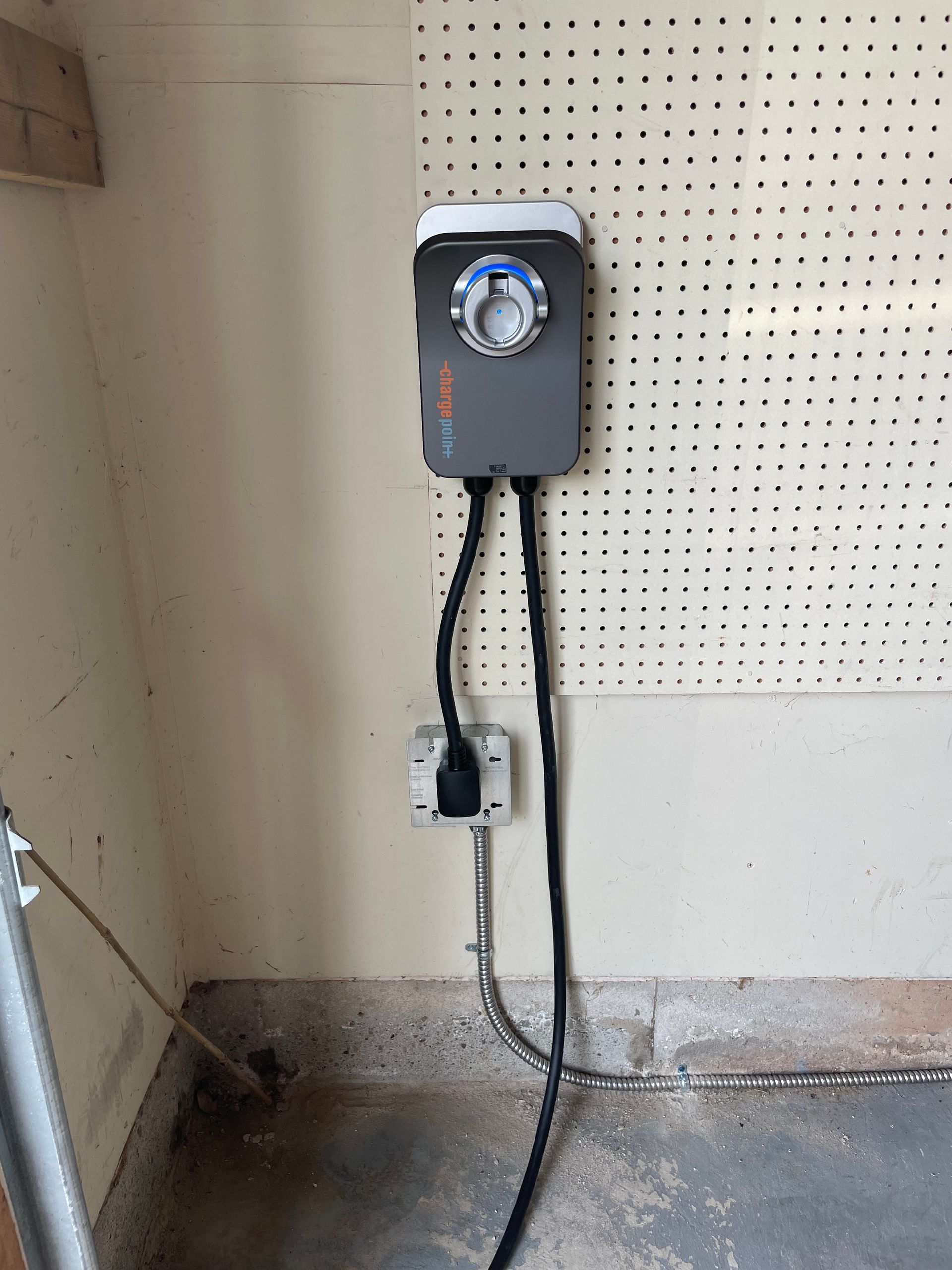 A timer is plugged into a wall outlet in a garage.