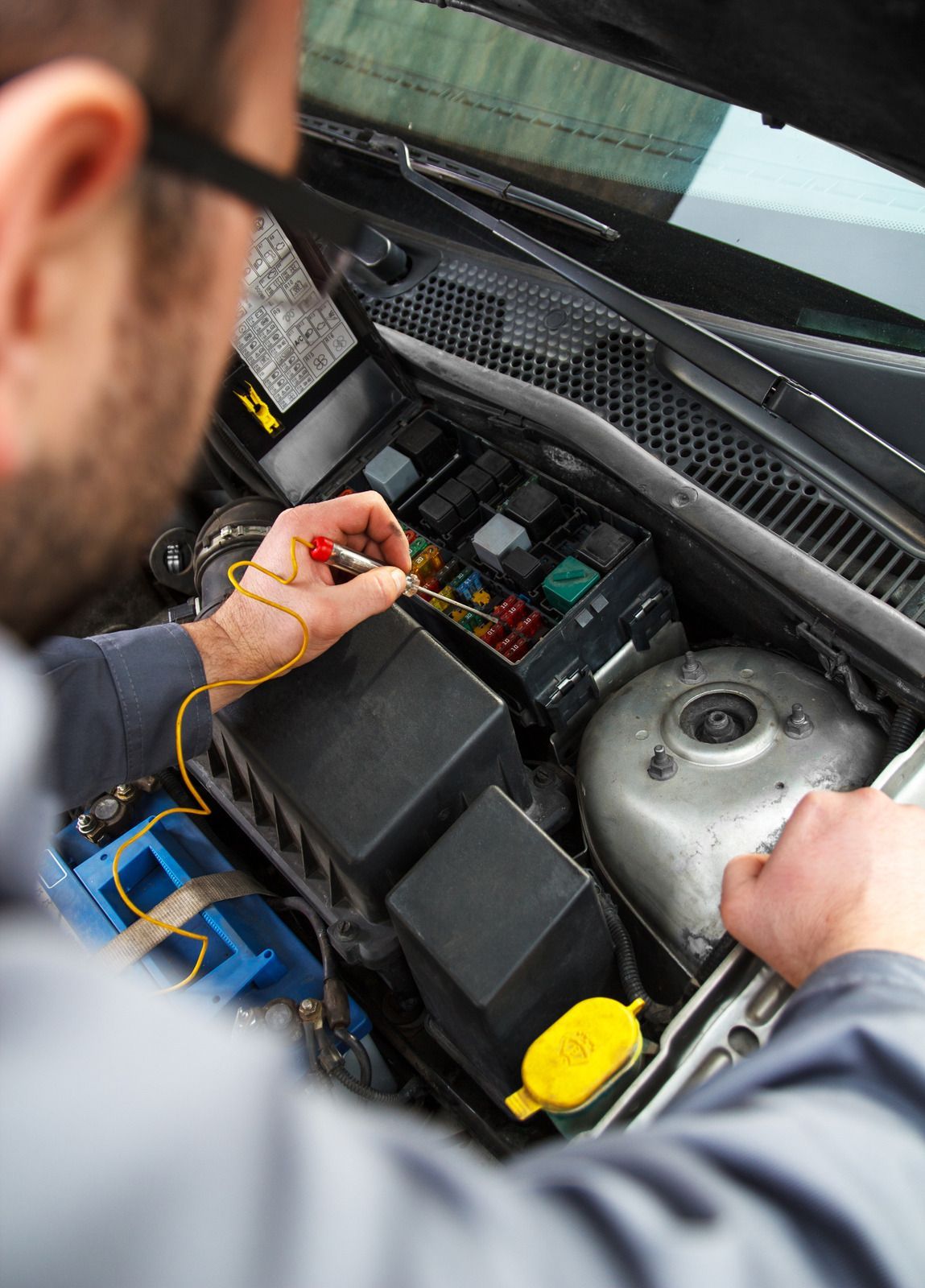 A man is working on the engine of a car.