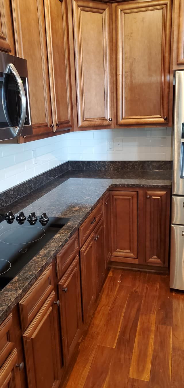 A kitchen with white cabinets and a black stove top oven.