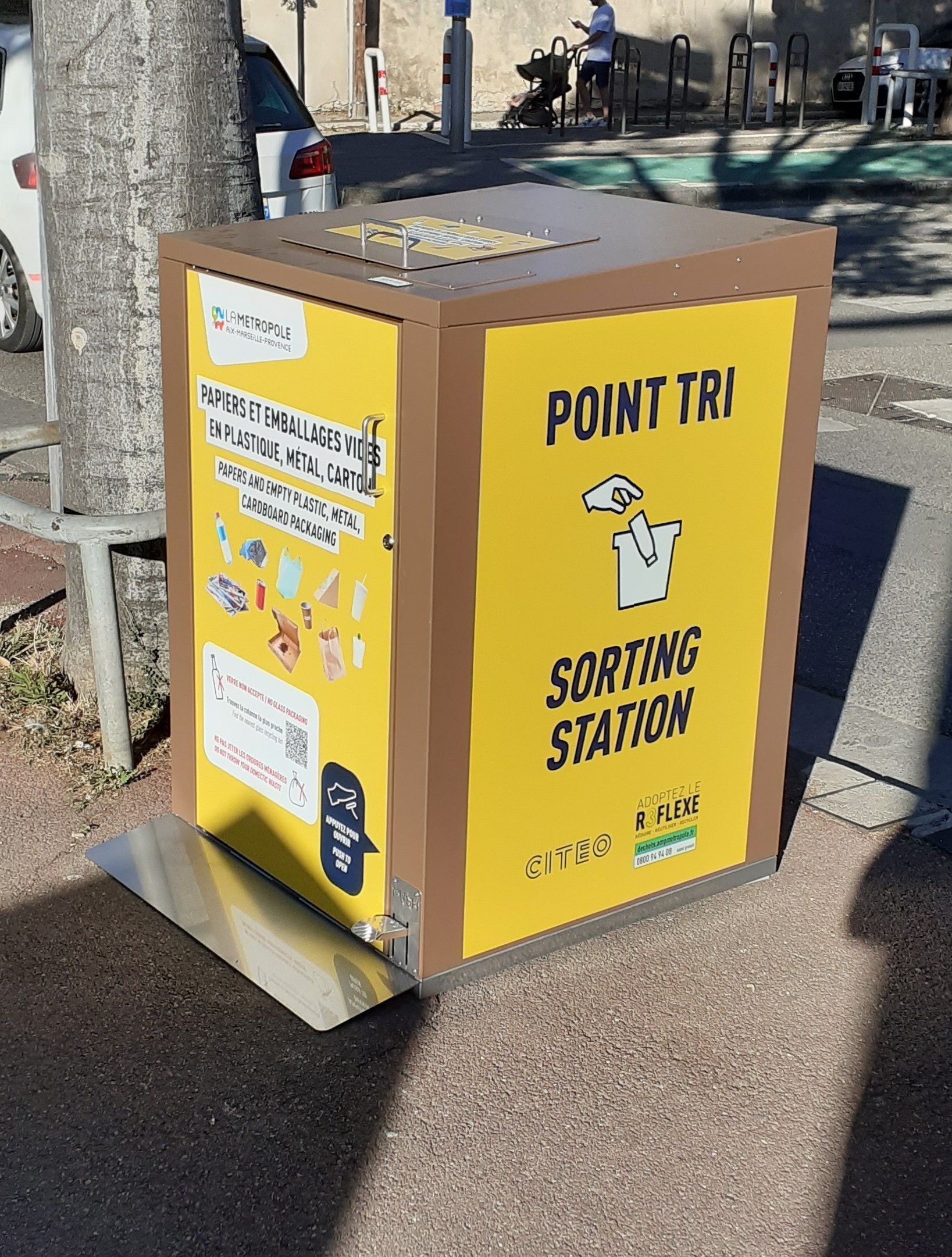 Une station de tri jaune et marron avec des instructions et un symbole de recyclage.