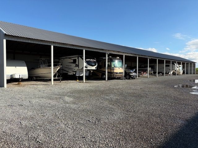 Man inspecting solar panel equipment on a brick wall. Silver panel, white boxes, green ivy.