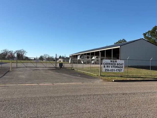 Solar panel installers working on a rooftop, one smiling, holding a panel. Others watching.