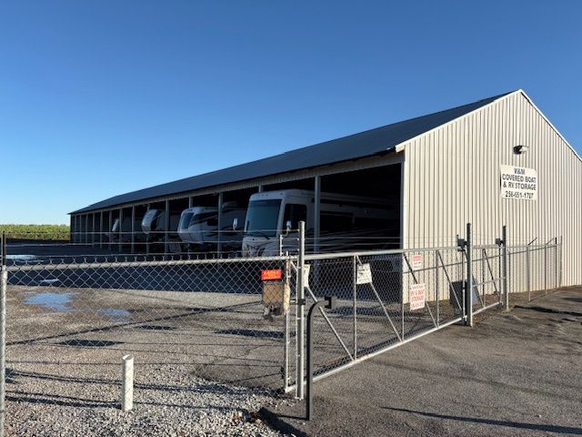Solar panel installer in orange safety gear on a rooftop, working on panels in the sun.