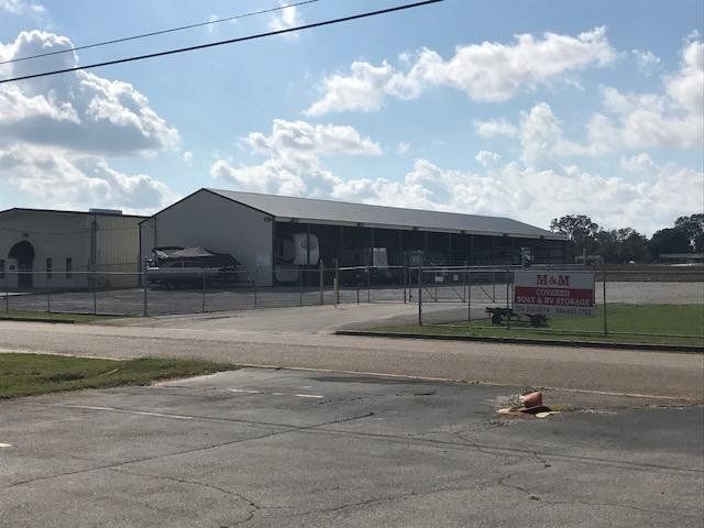 Rooftop solar panel installer in orange vest and hard hat working on panels during sunset.