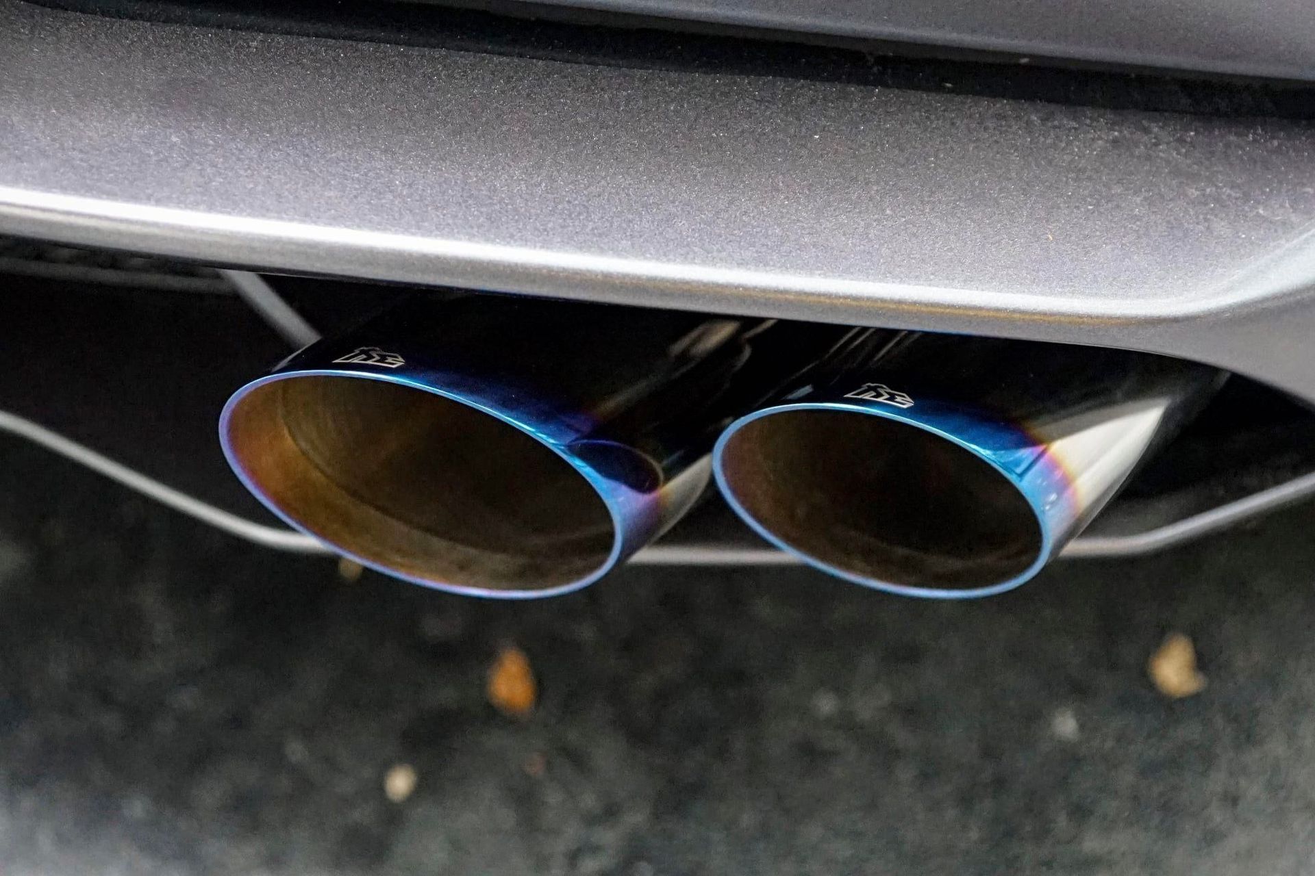 Dual exhaust pipes with blue and bronze coloration.