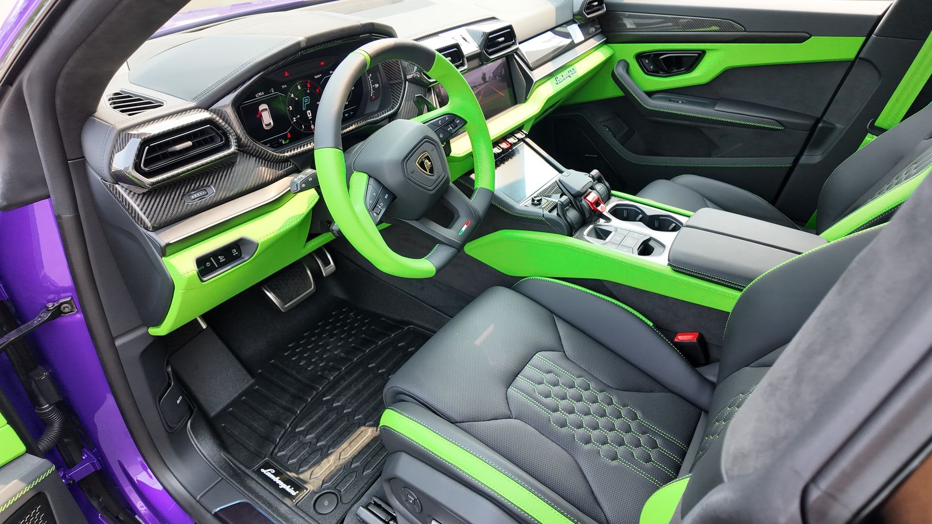 Purple Lamborghini Urus interior with green accents on the dashboard, steering wheel, and trim.