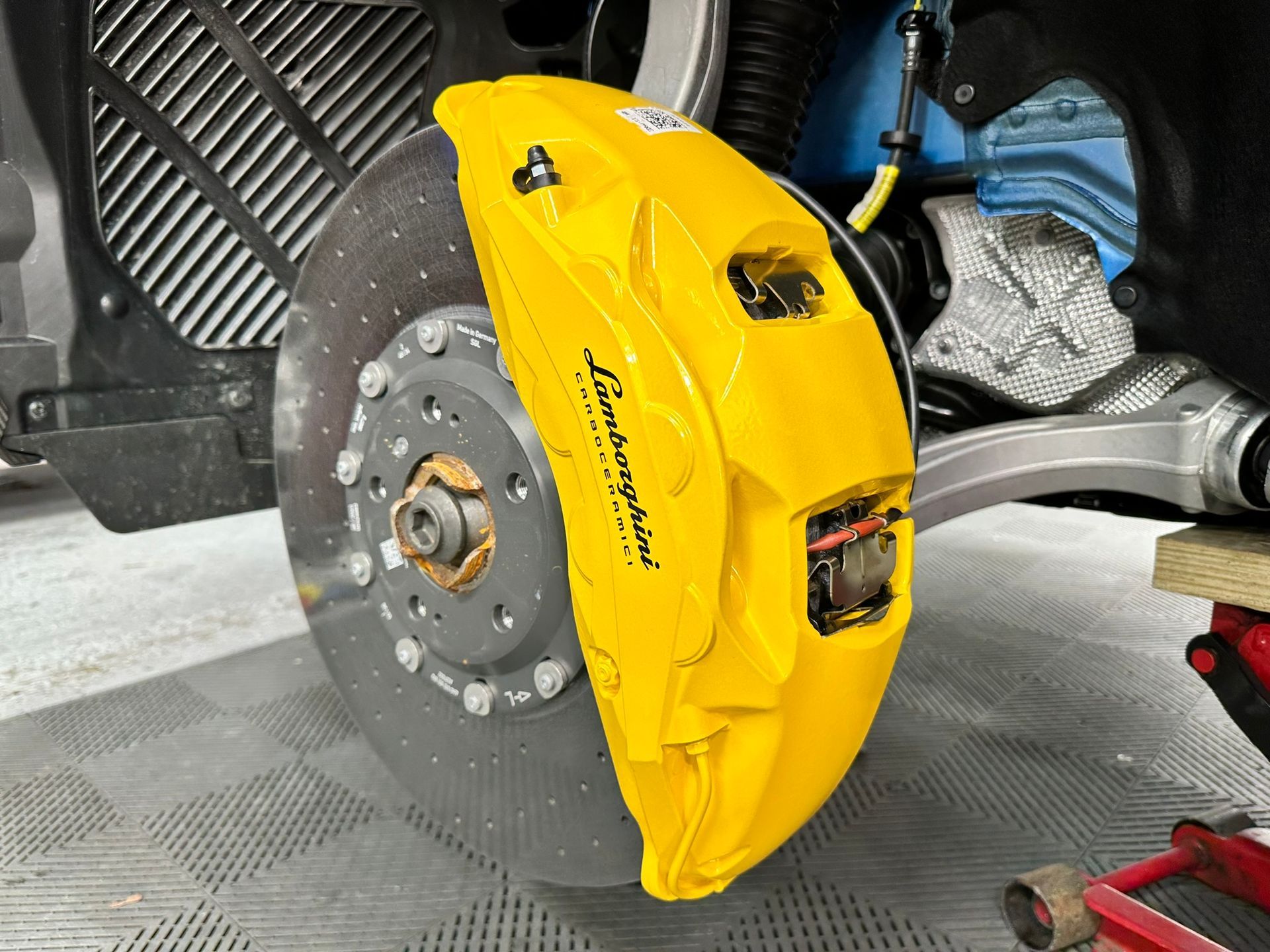 Yellow Lamborghini brake caliper with a rotor.