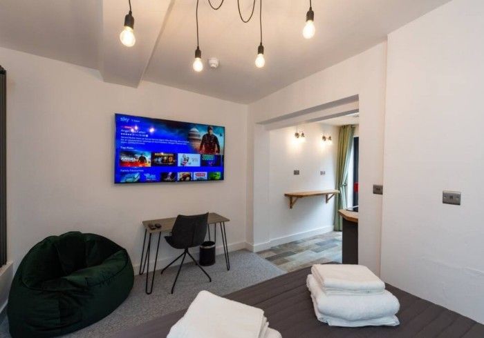 A bedroom with a large flat screen tv on the wall