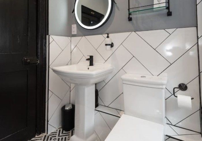A bathroom with a toilet , sink and mirror