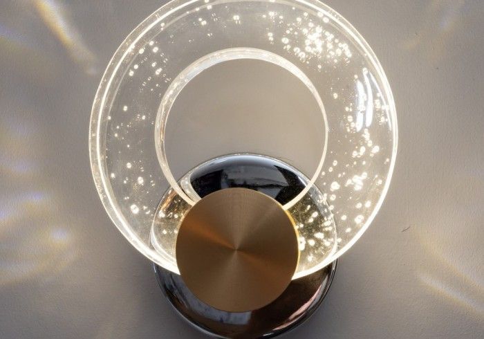 A close up of a wall light with a clear glass sphere