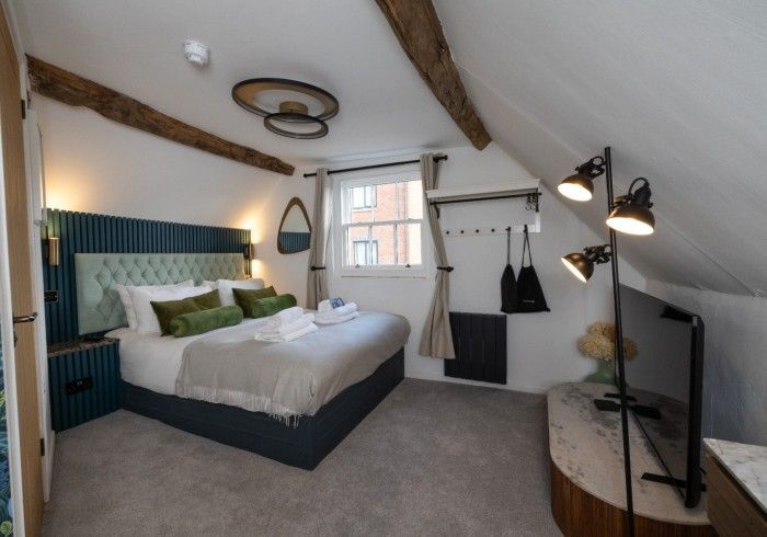 A bedroom with a king size bed and a flat screen tv