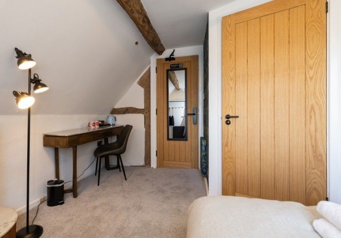 A bedroom with a desk and chair in it