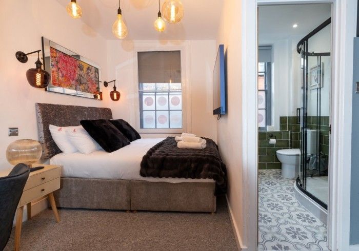 A bedroom with a large bed and a bathroom