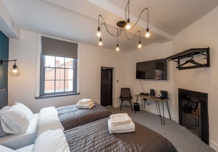 A hotel room with two beds and a flat screen tv