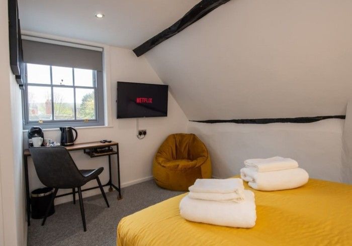 A bedroom with a bed , chair , desk and television.