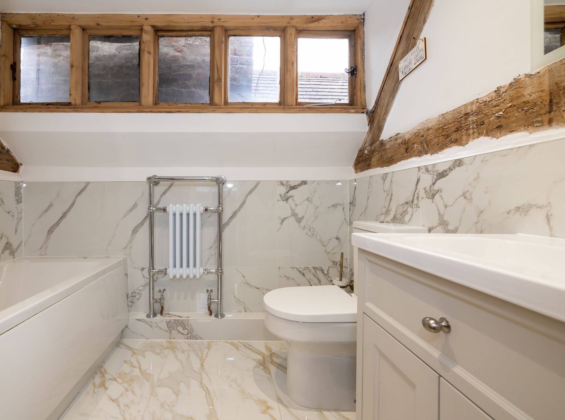 A bathroom with a toilet , sink , and bathtub.