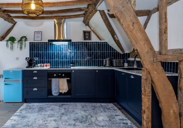 A kitchen with blue cabinets and a blue refrigerator.