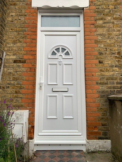 A white door is sitting on a brick wall.