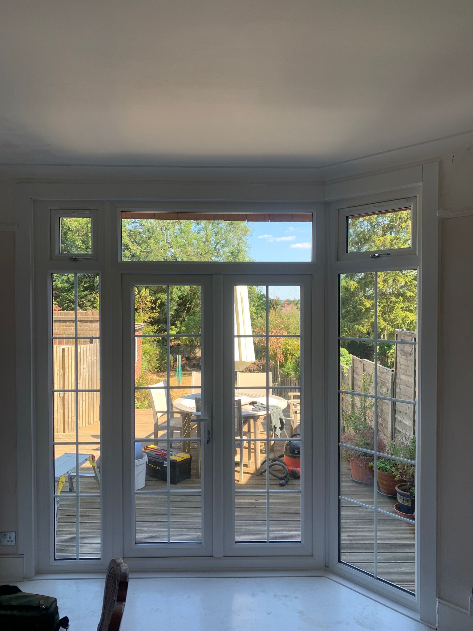 A living room with a lot of windows and a view of a deck.