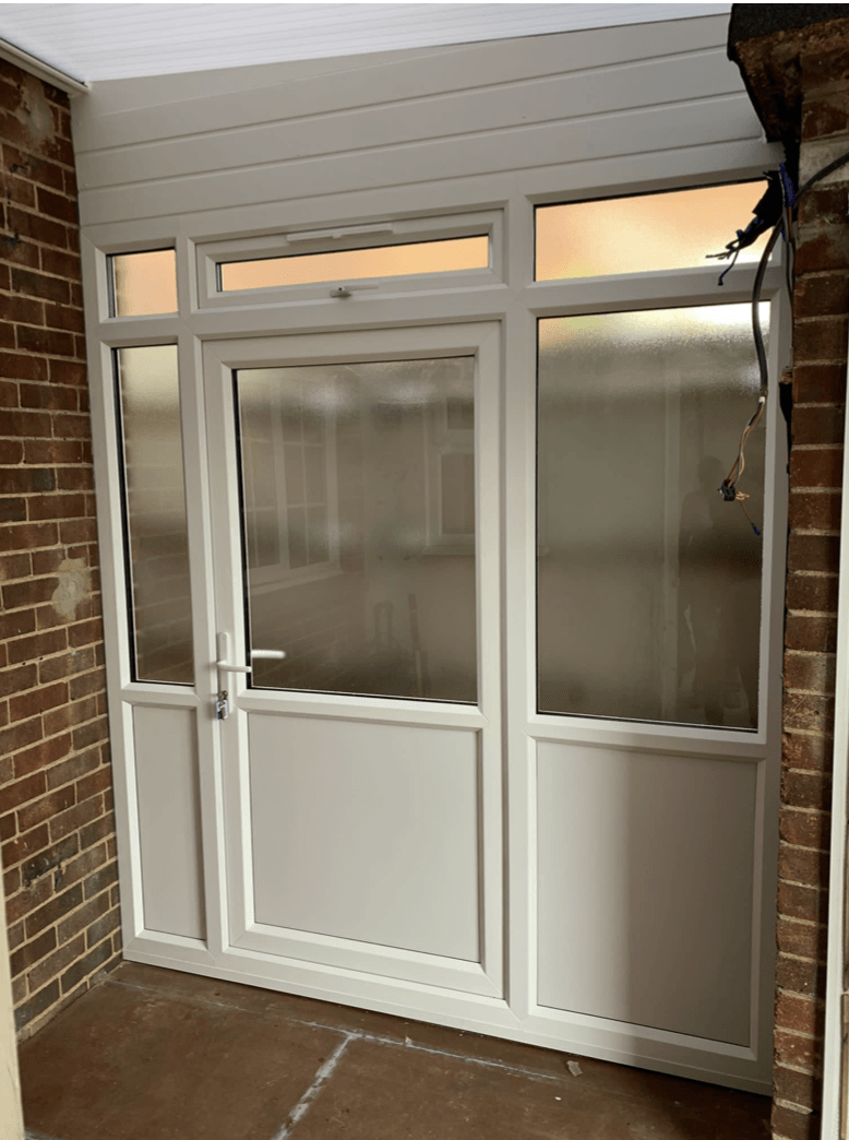 A white door with a brick wall behind it