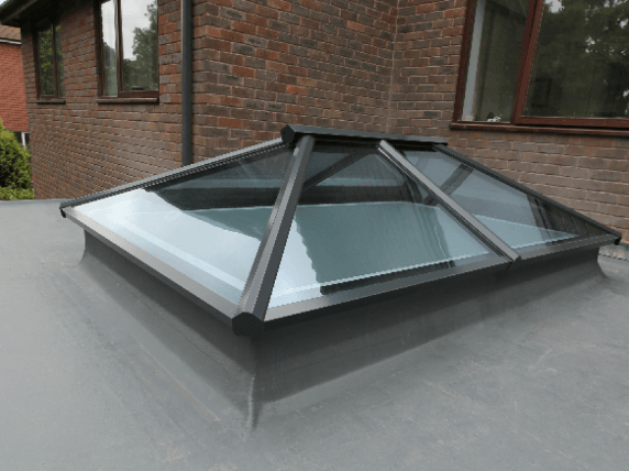A skylight on the roof of a brick house.