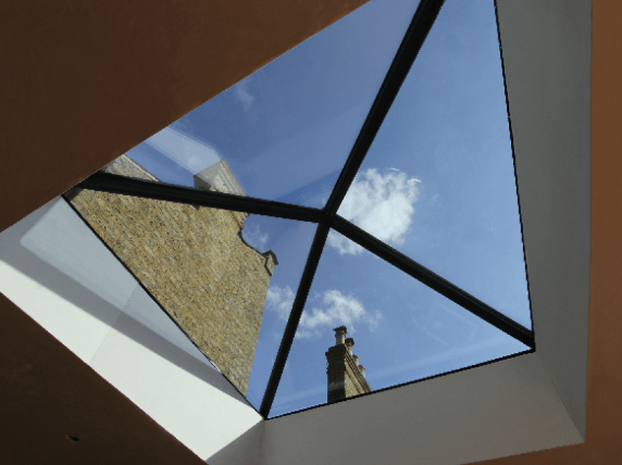 Looking up through a skylight at a chimney