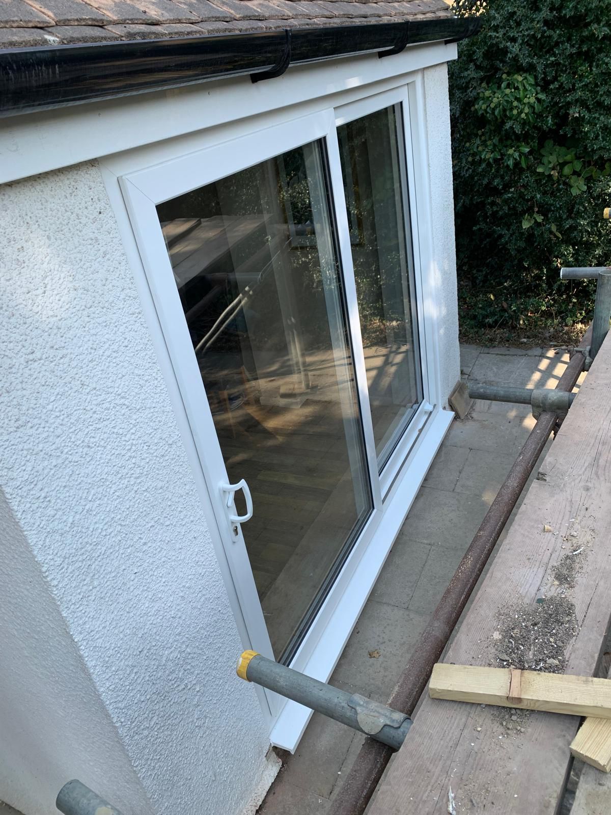 A sliding glass door is being installed on the side of a building.