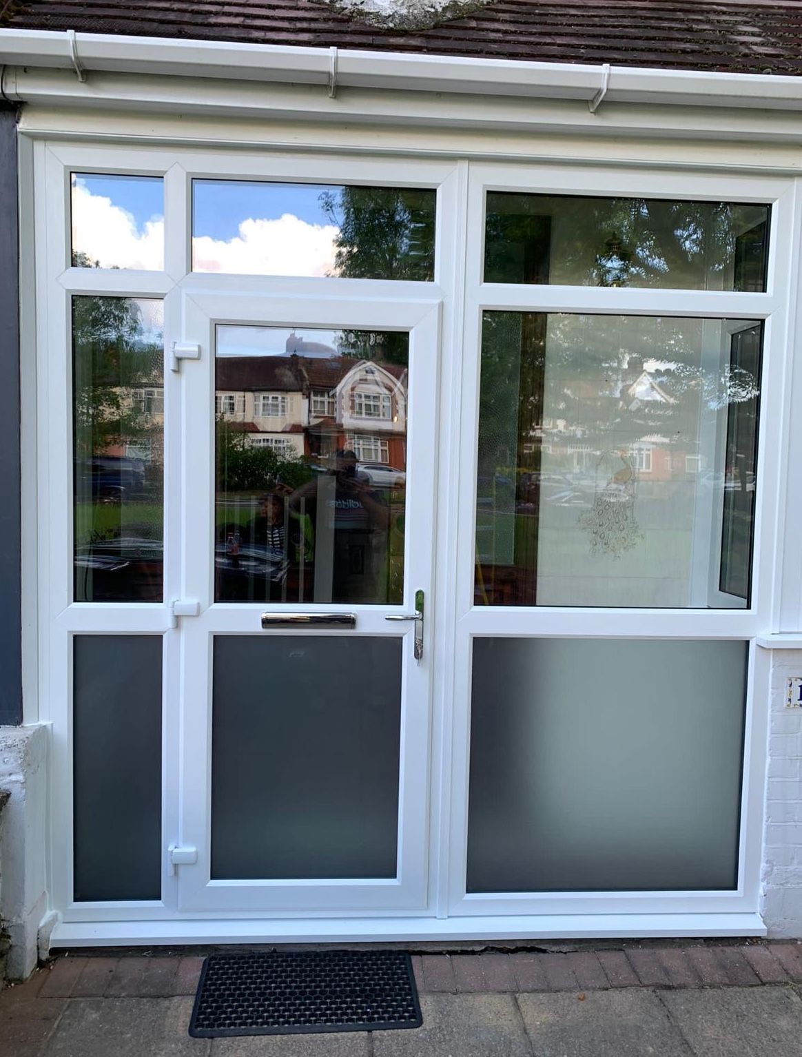 A white door with a mat on the ground in front of it.