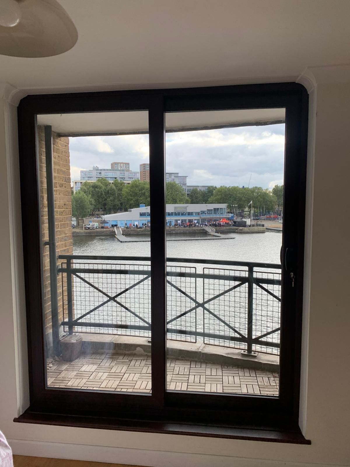 A large window with a view of a river and a balcony.