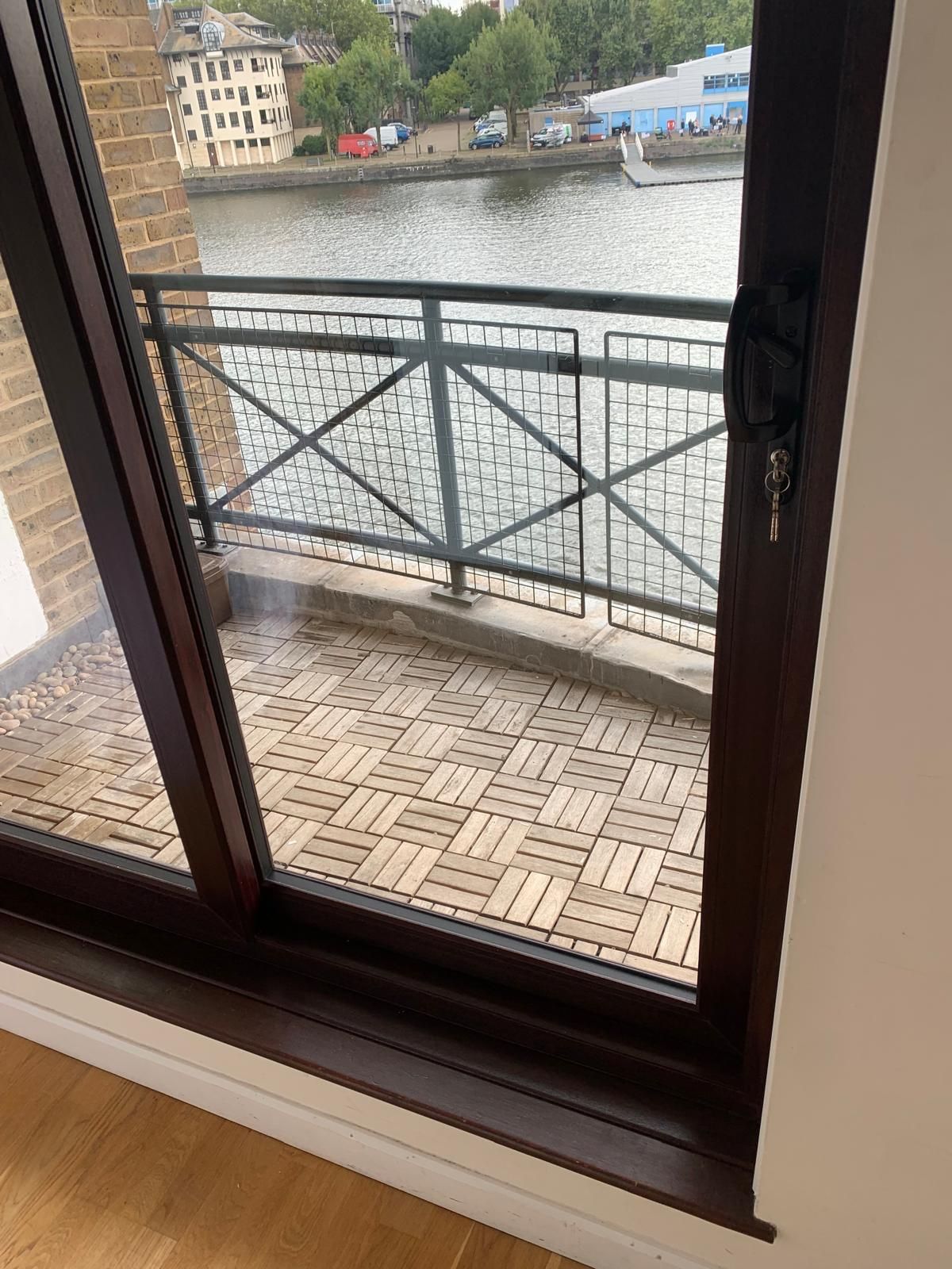 A sliding glass door leading to a balcony overlooking a body of water.