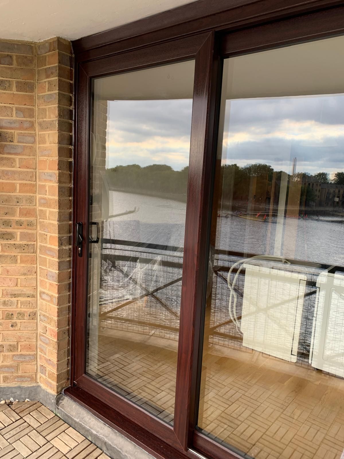 A sliding glass door leading to a balcony overlooking a body of water.