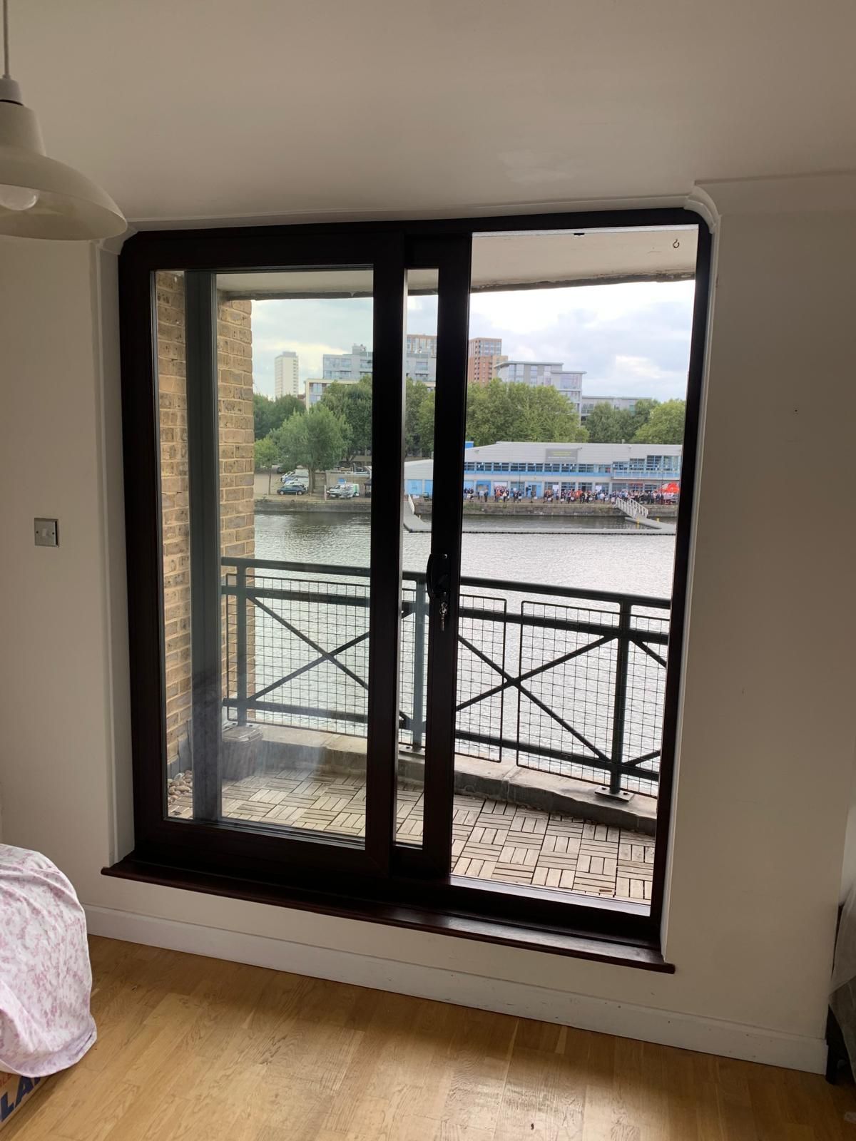 A room with a sliding glass door leading to a balcony overlooking a body of water.