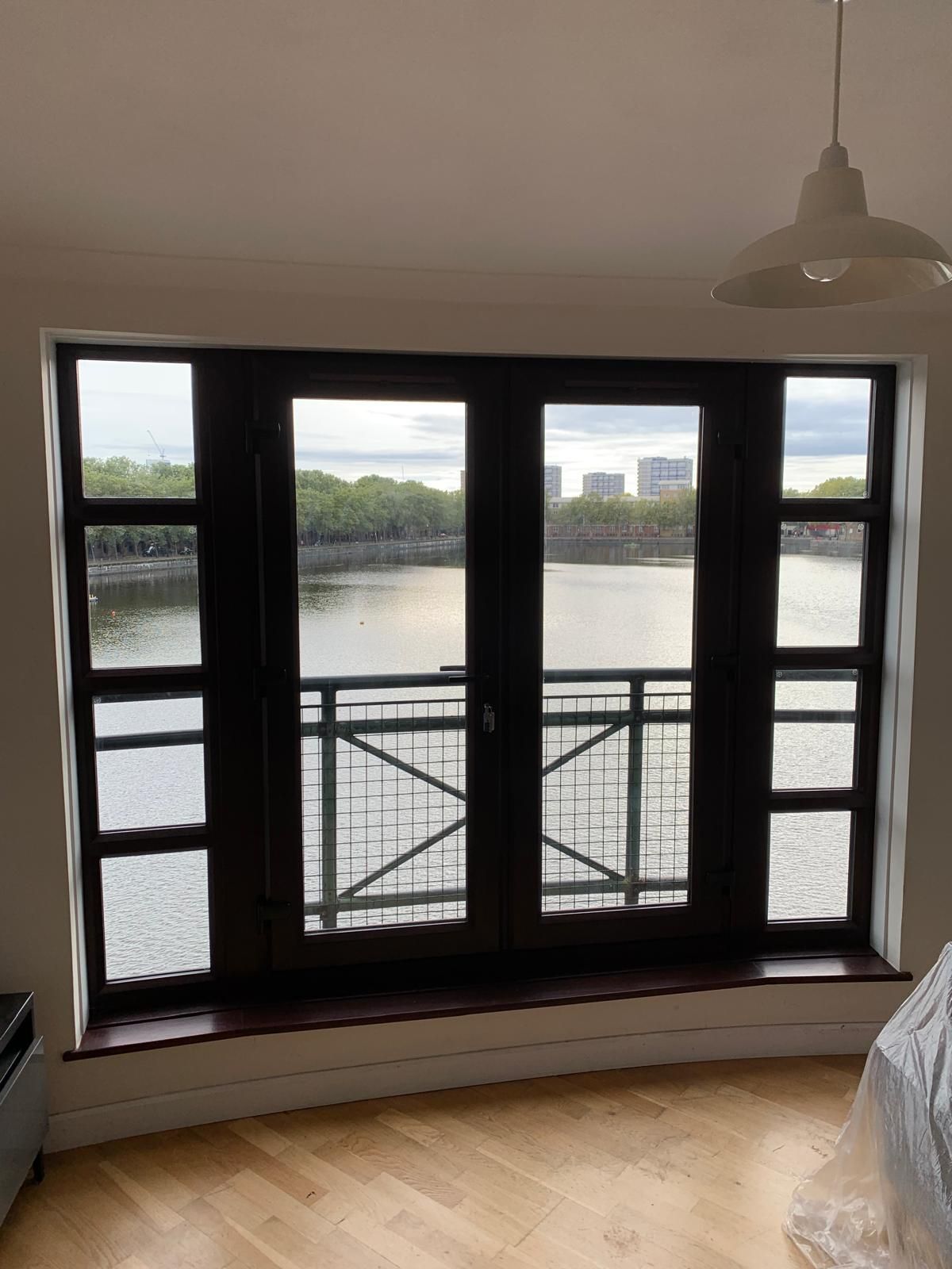 A living room with a large window overlooking a body of water.