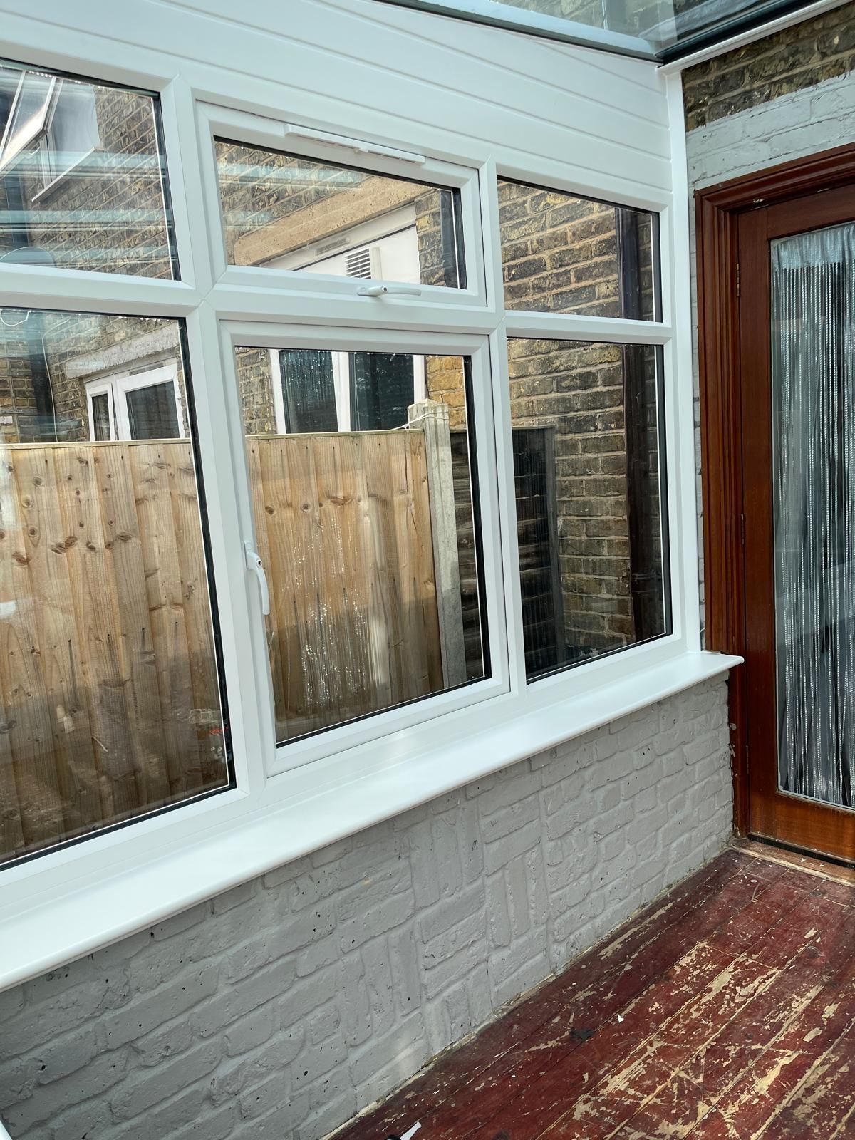 A conservatory with a lot of windows and a wooden door.