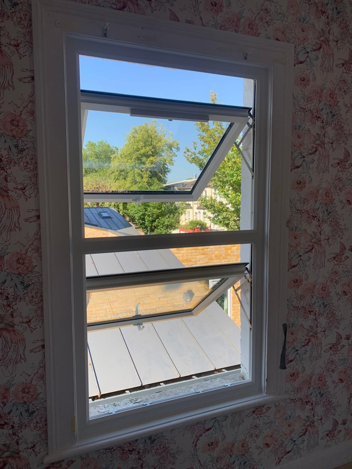 A window in a room with a view of a roof and trees