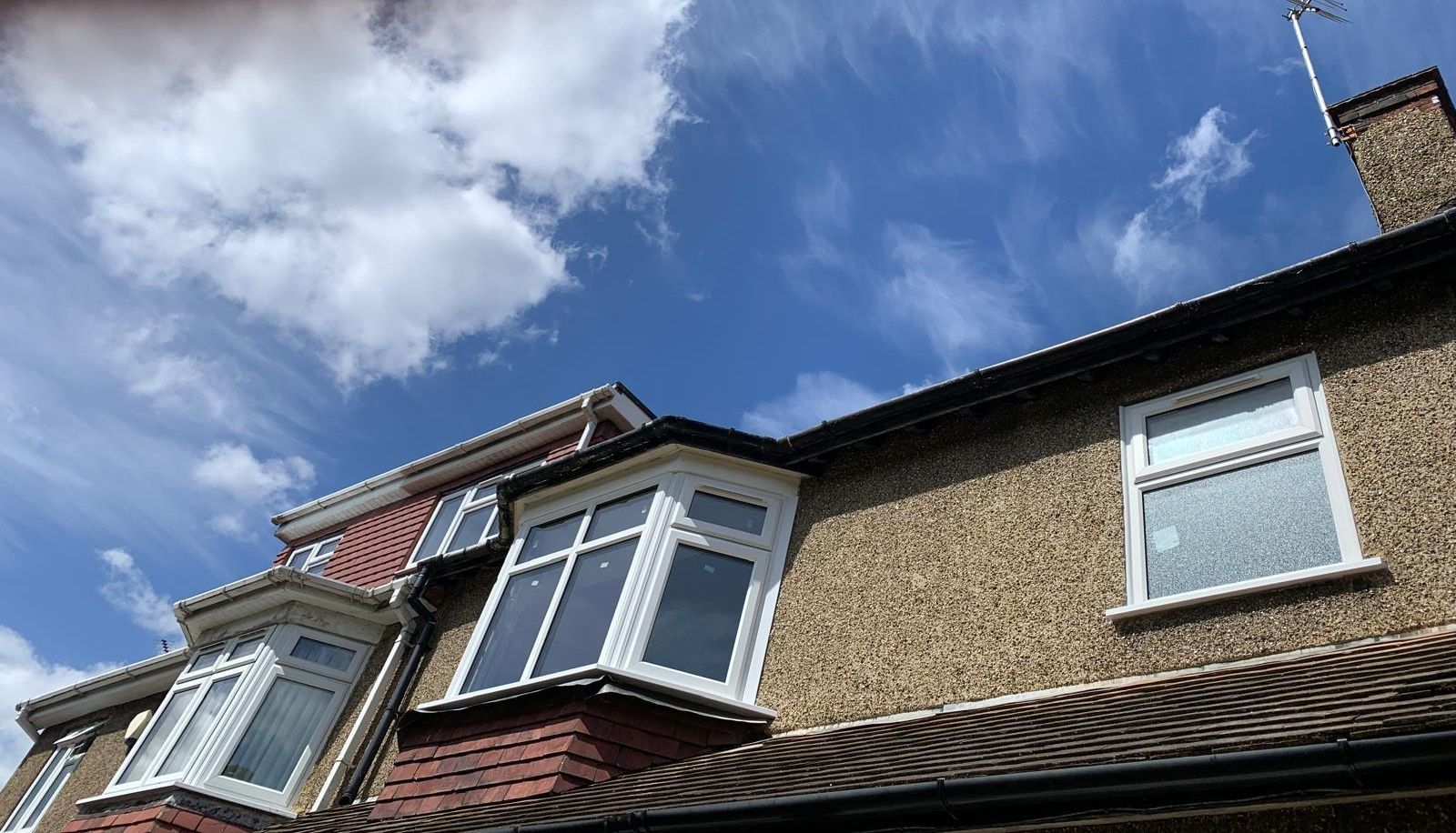 A house with a lot of windows and a blue sky in the background.