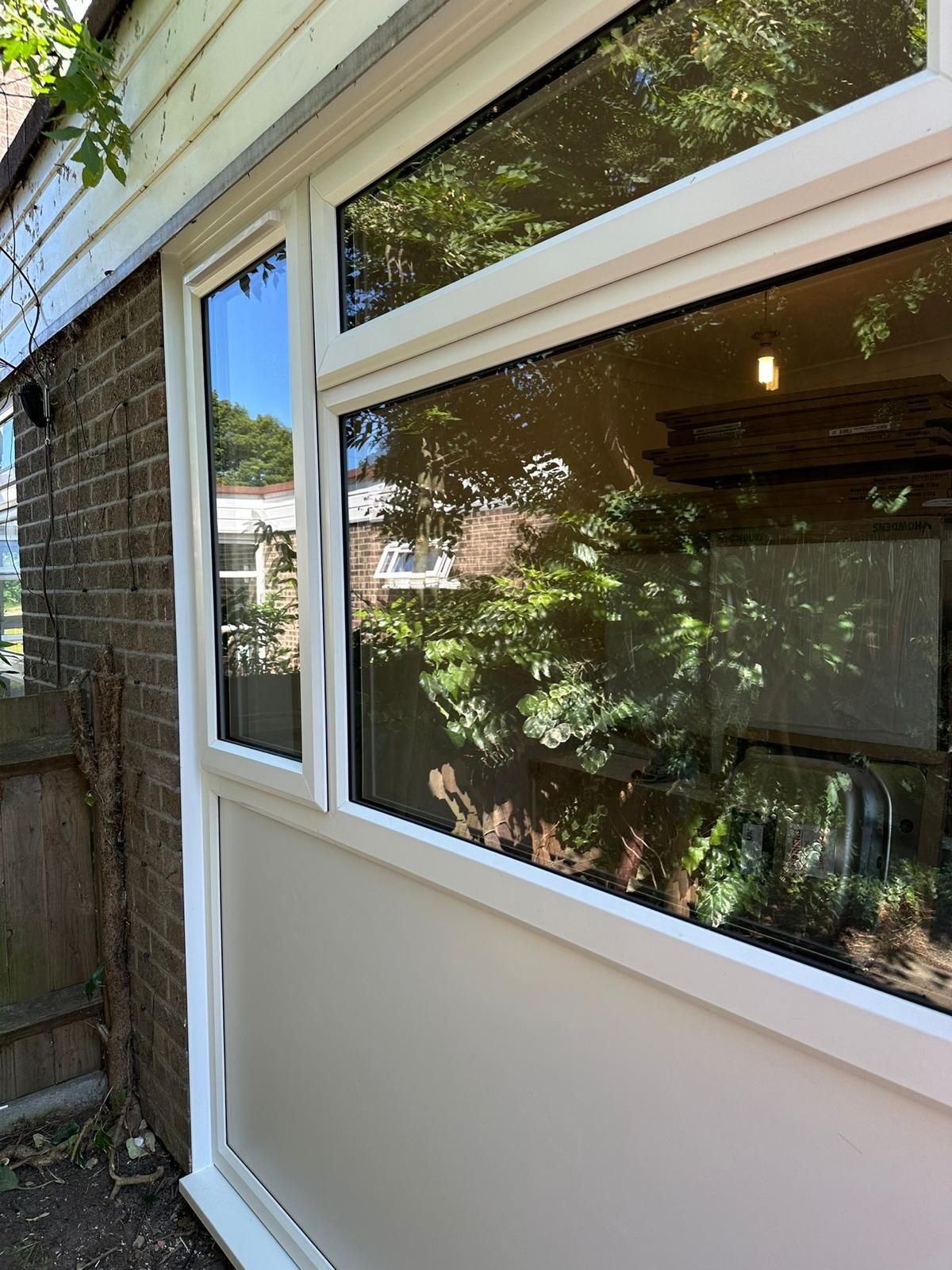 A white door with a large window on the side of a brick building.