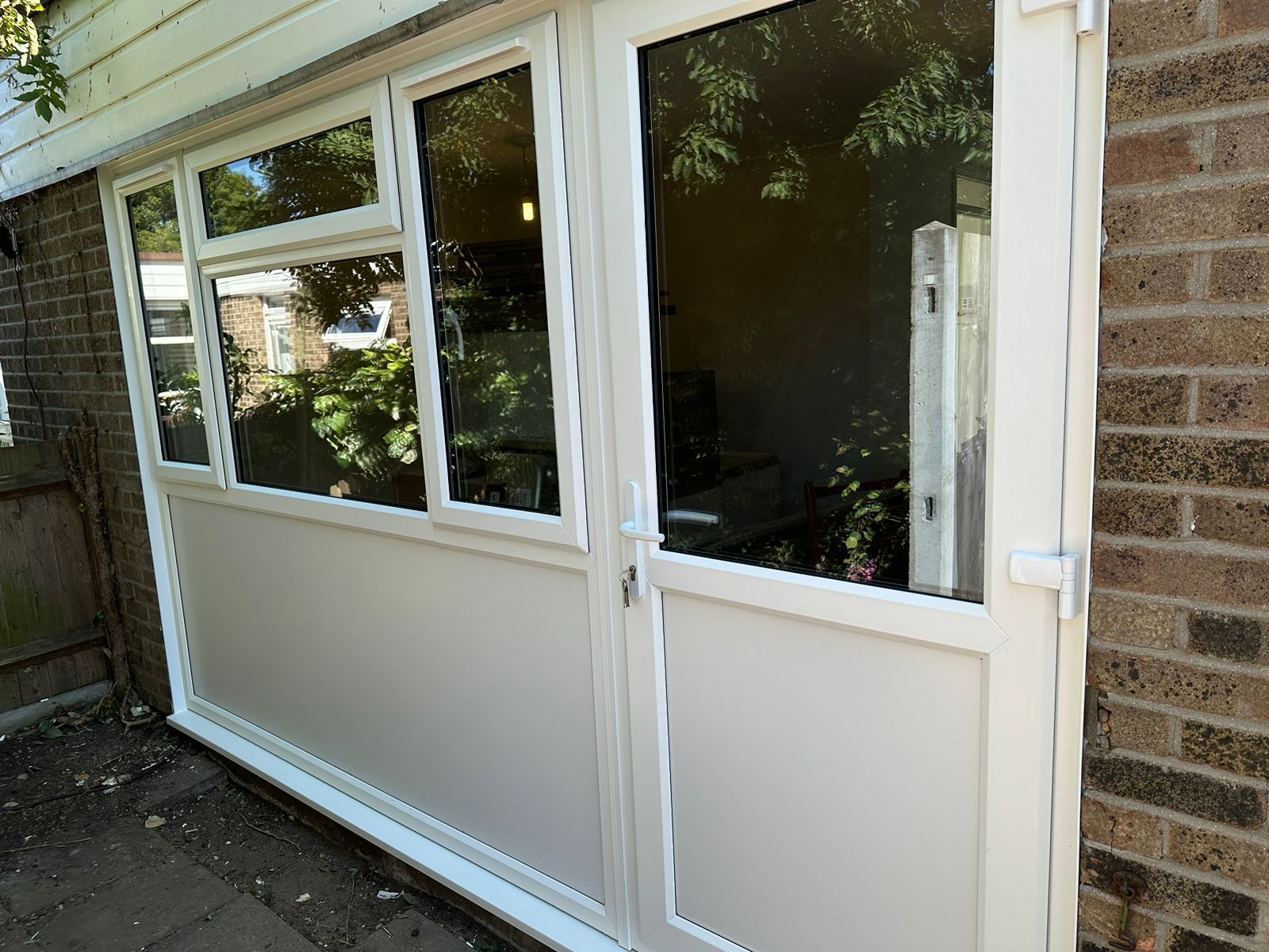 A white door with a lot of windows on a brick building.