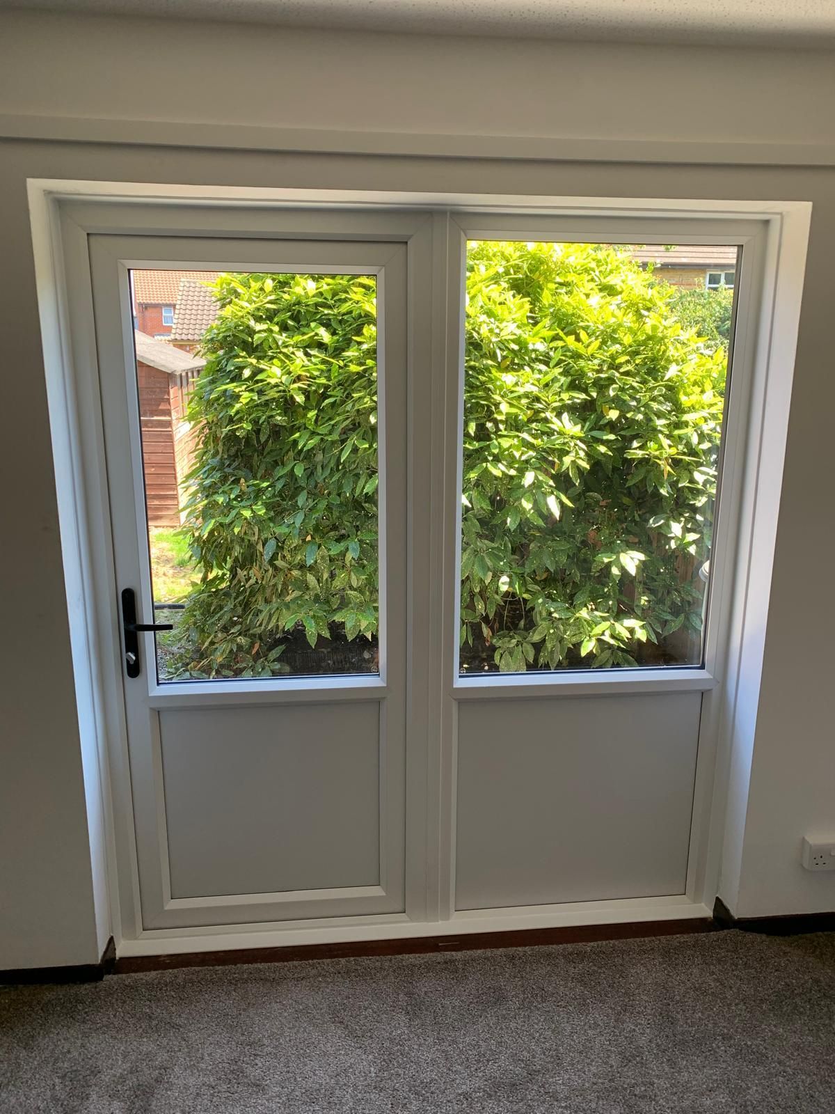 A white door with a view of a tree in a room.