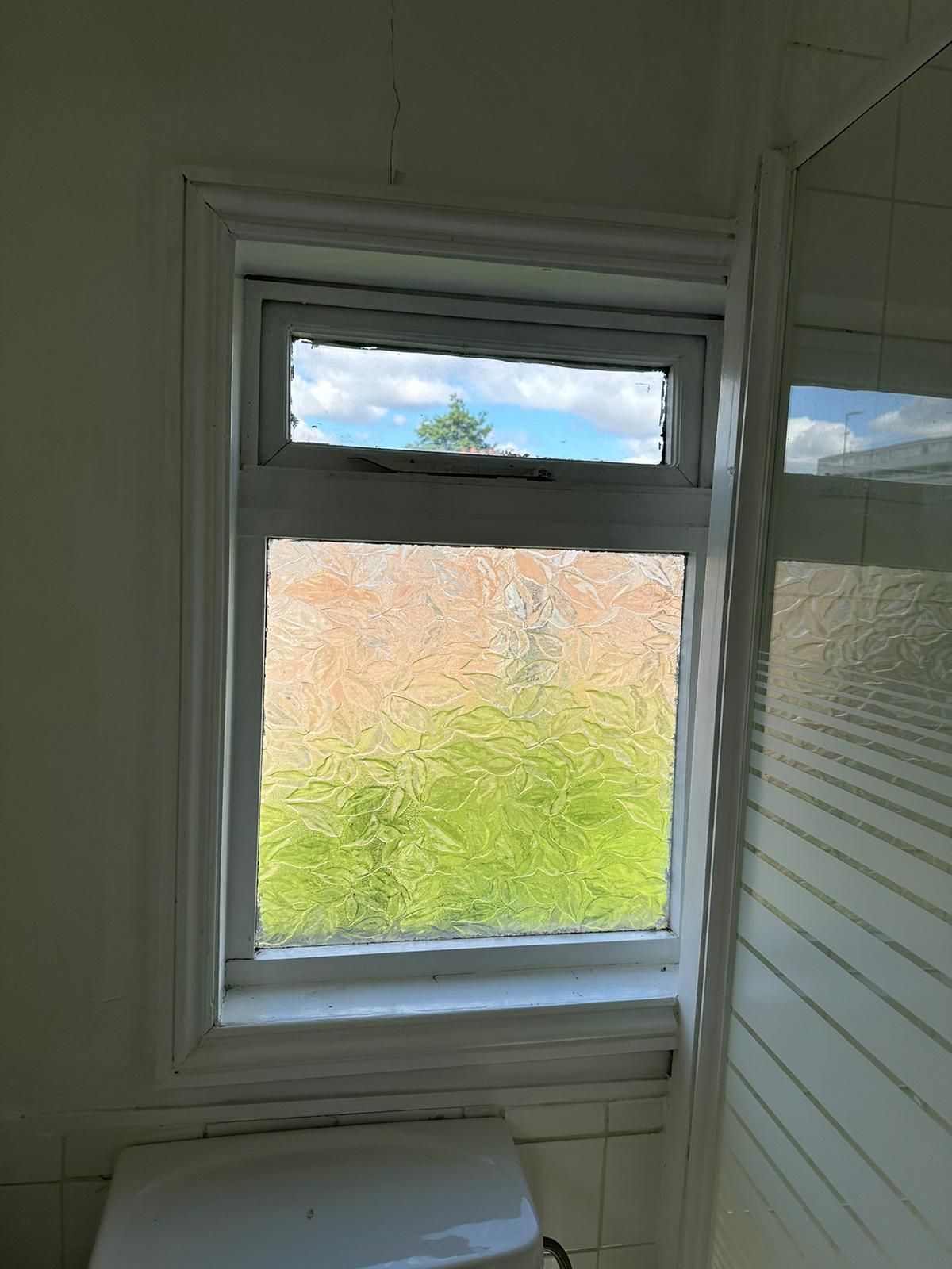 A bathroom with a window and a toilet