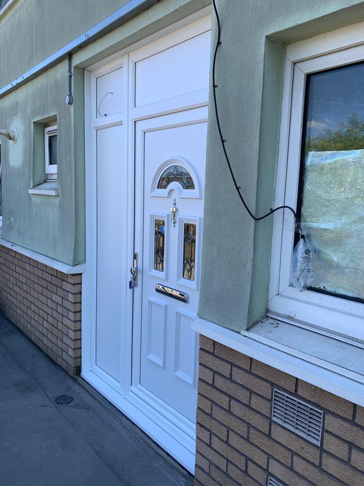 A white door is on the side of a brick building.