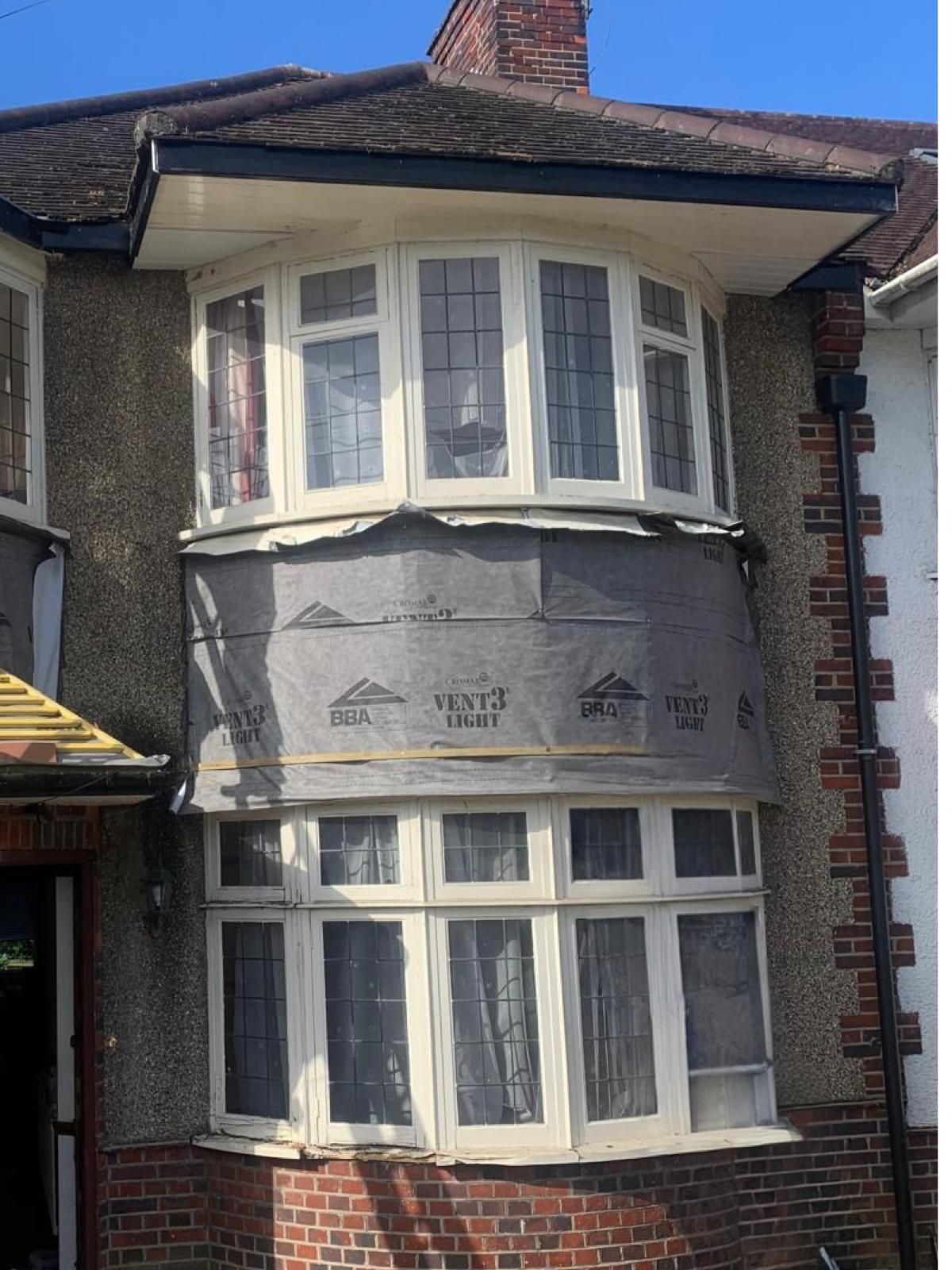 A house with a large bay window on the side of it.