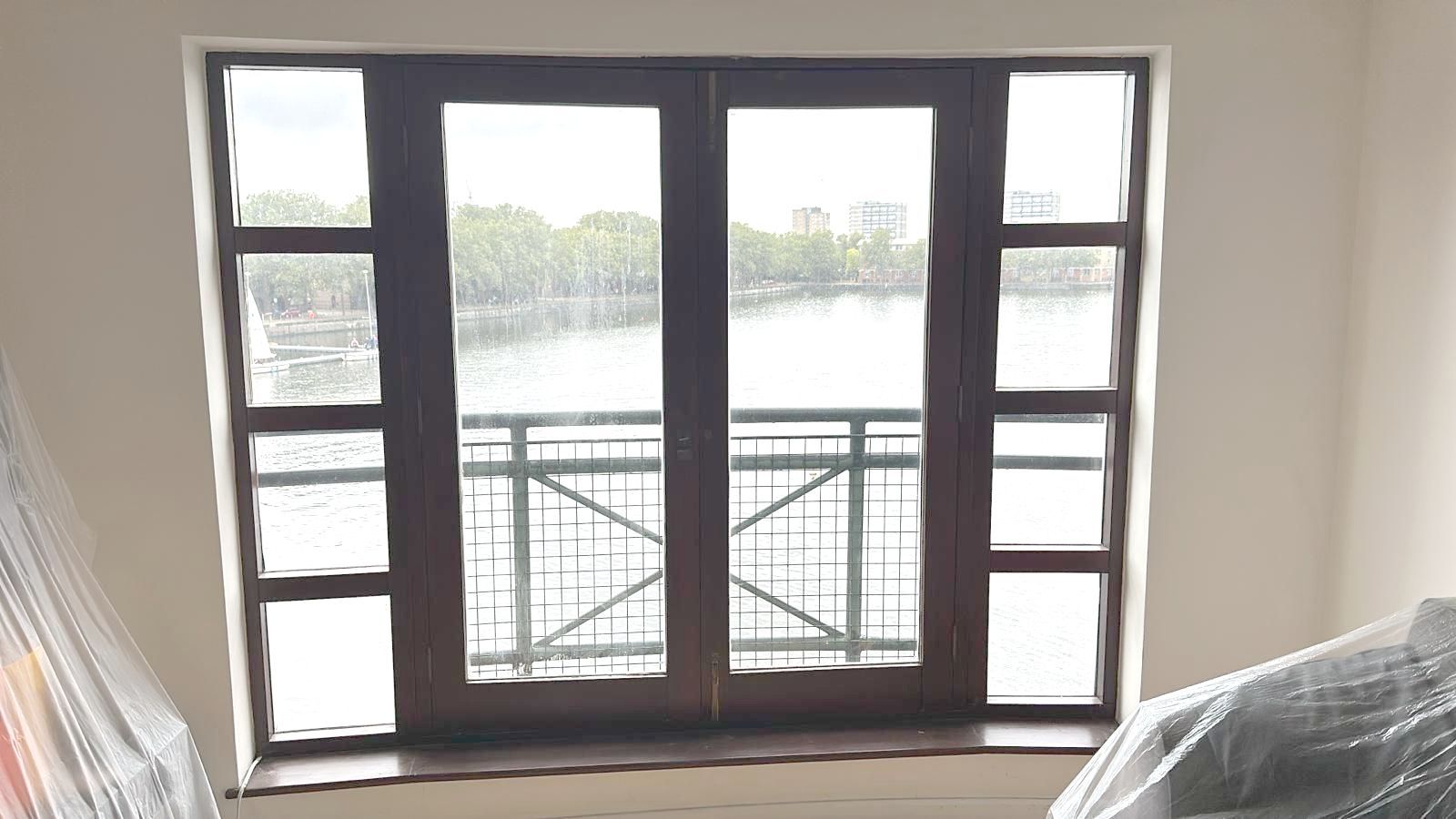 A large window in a room with a view of a lake.