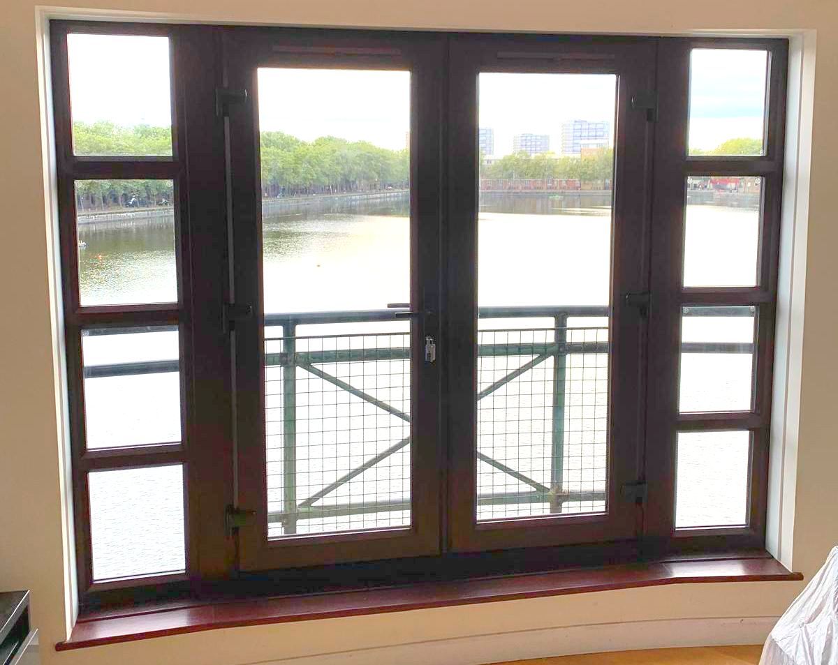 A large window with a balcony overlooking a body of water.