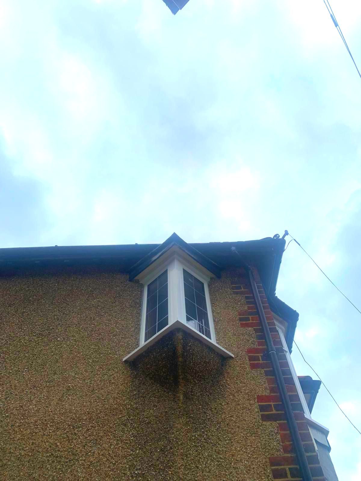 A window on the side of a building with a blue sky in the background.