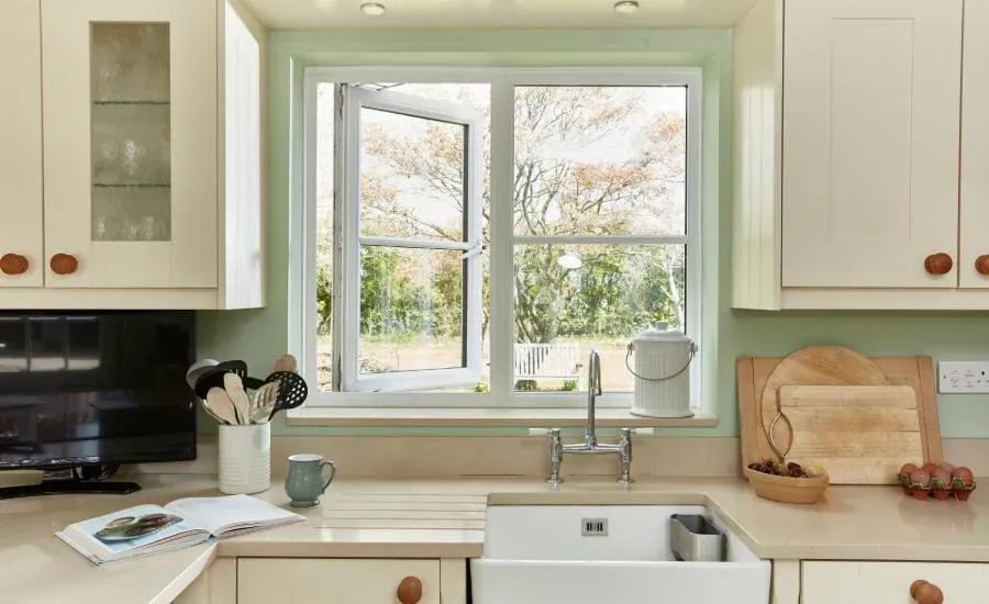 A kitchen with a sink , cabinets , and a window.