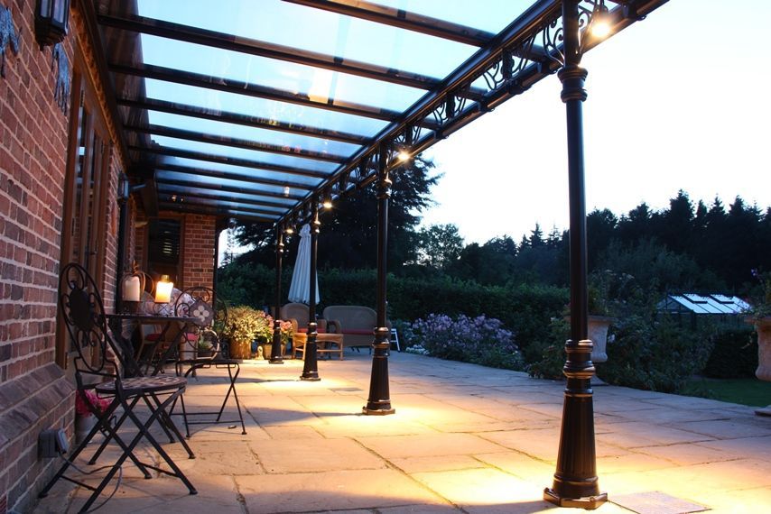 A patio with chairs and tables under a canopy at night